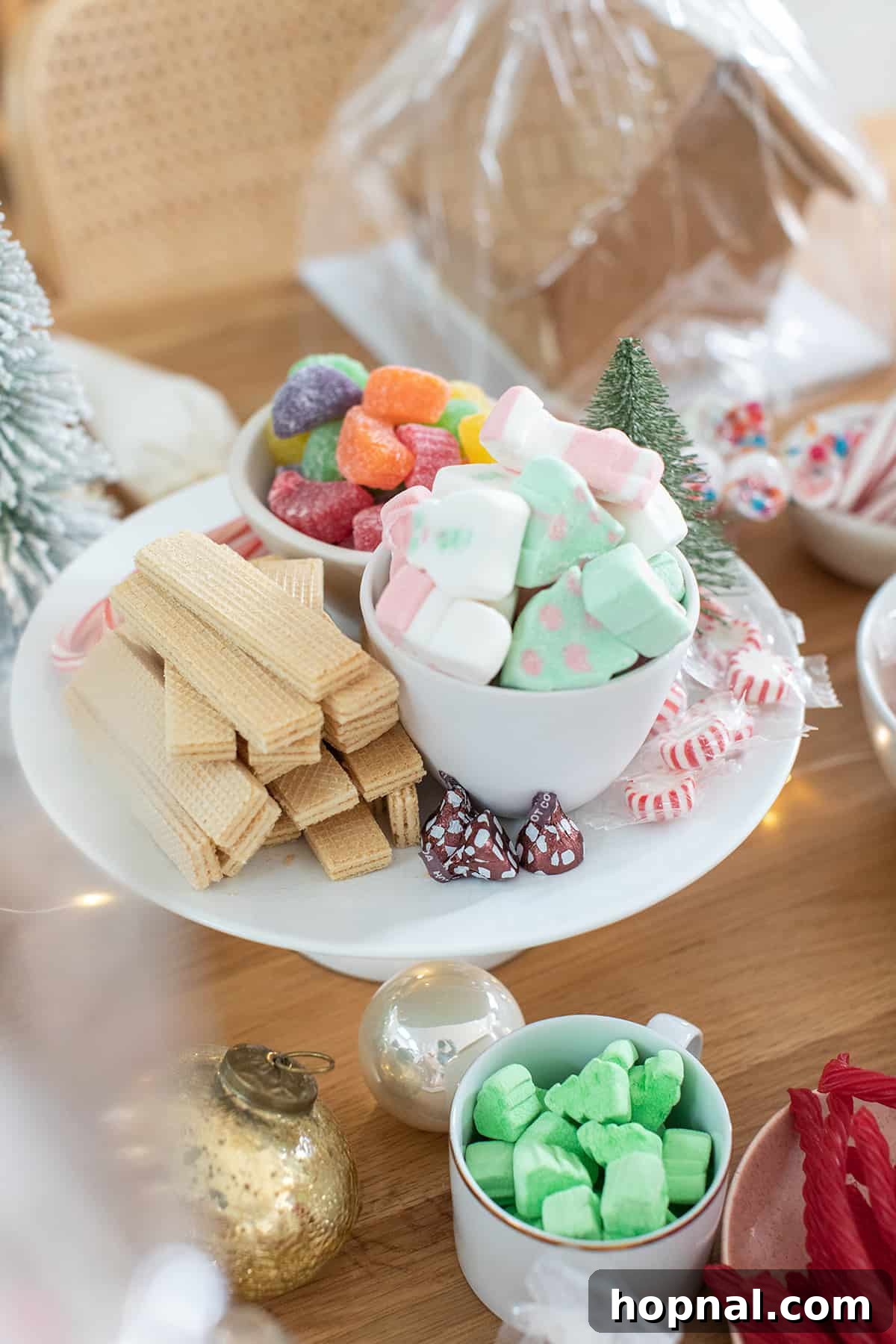 Bowls filled with colorful Christmas candies and sprinkles for gingerbread house decorating.