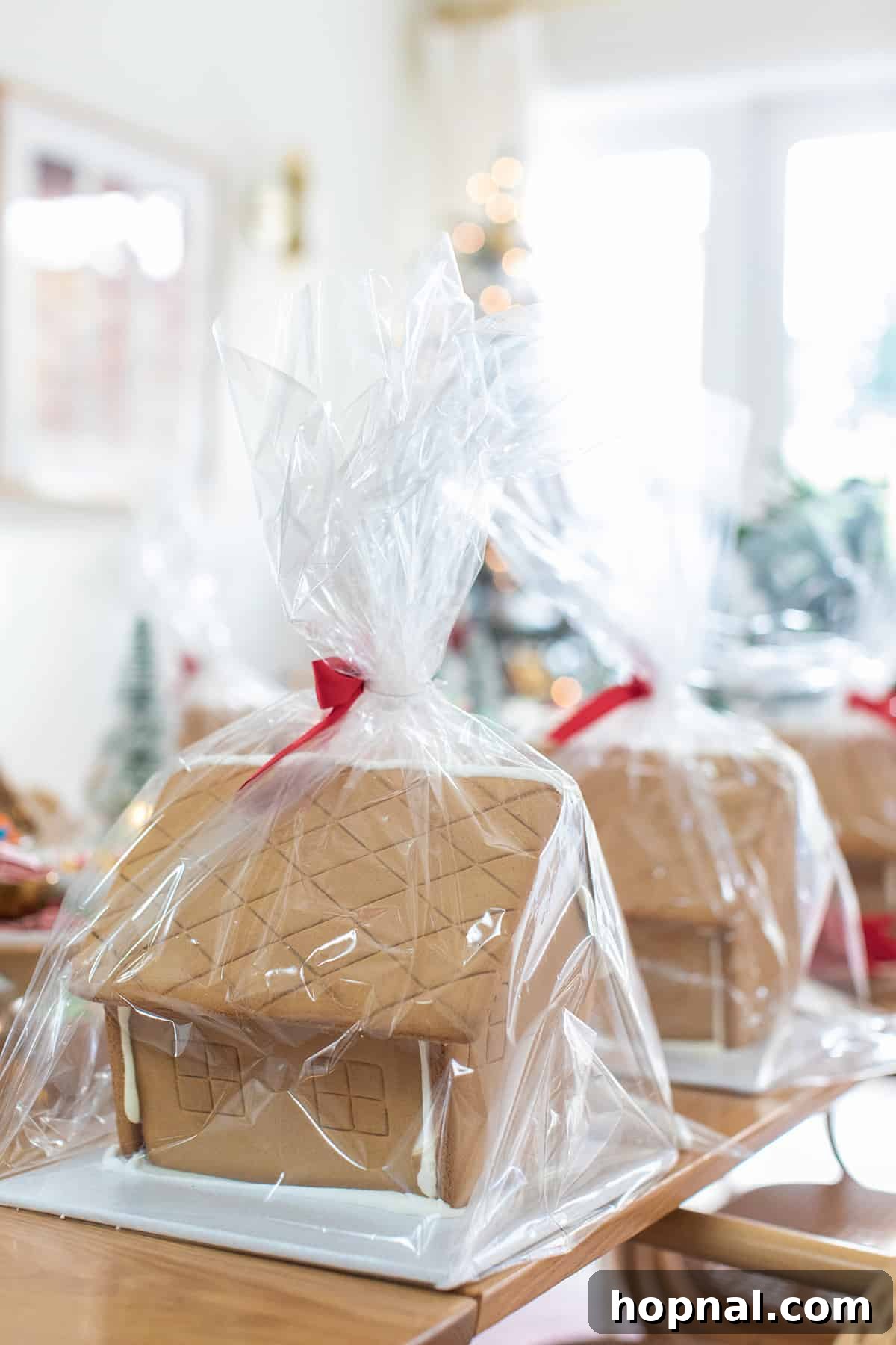 Individually wrapped gingerbread house kits displayed on a rustic table, ready for a party.