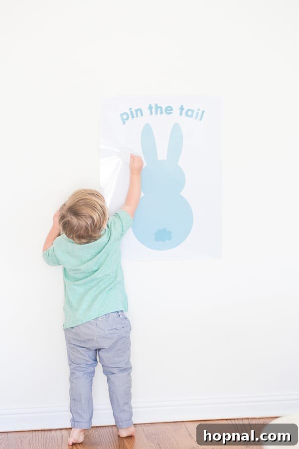 A child enthusiastically playing 'Pin the Tail on the Easter Bunny' at an Easter party.