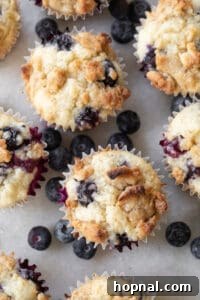 Golden Banana Blueberry Treats 16 Fluffy blueberry banana muffins baking in a muffin tin, rising and turning golden brown.