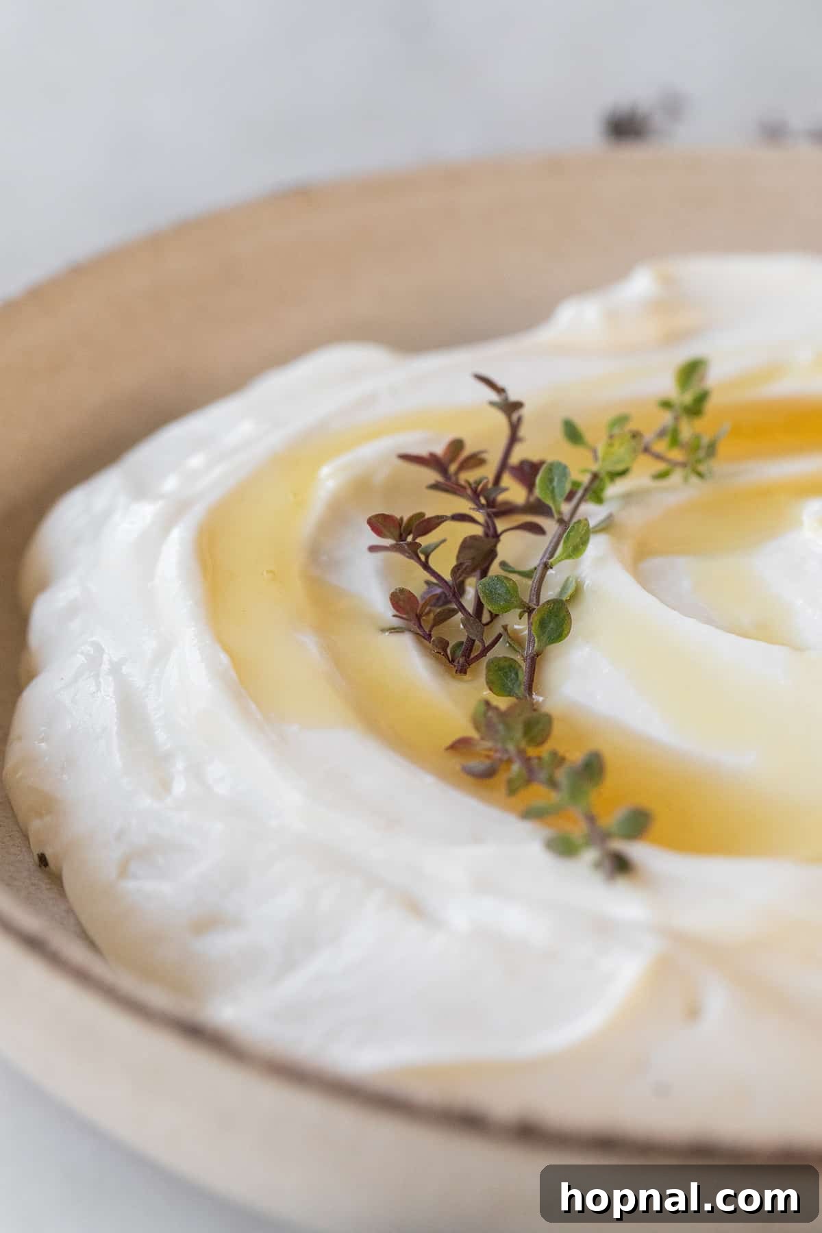 Whipped ricotta in a bowl with honey and thyme, ready to be served as an appetizer.