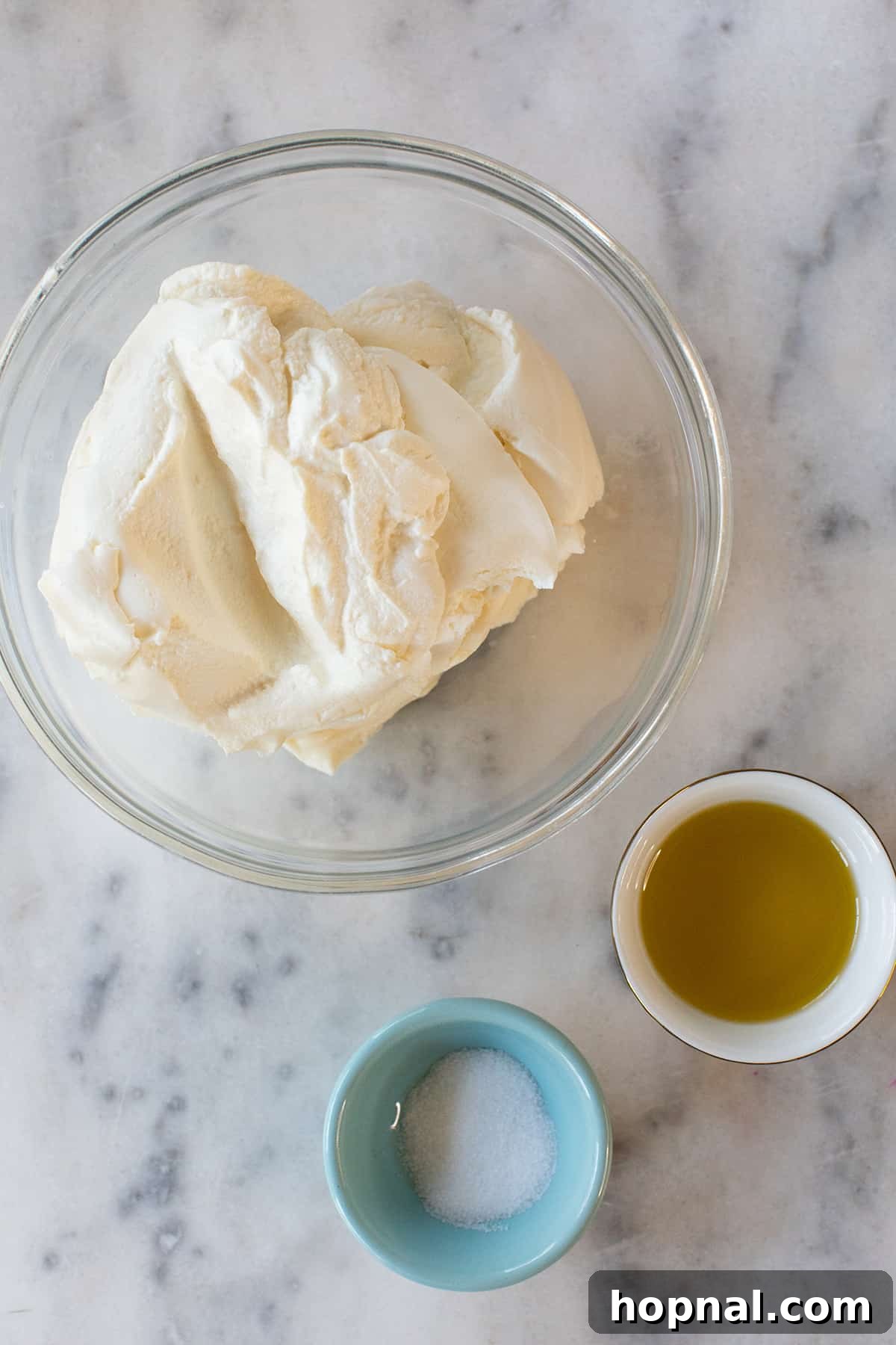 Ricotta, olive oil, and salt in small bowls, showcasing the fresh ingredients for the dip.
