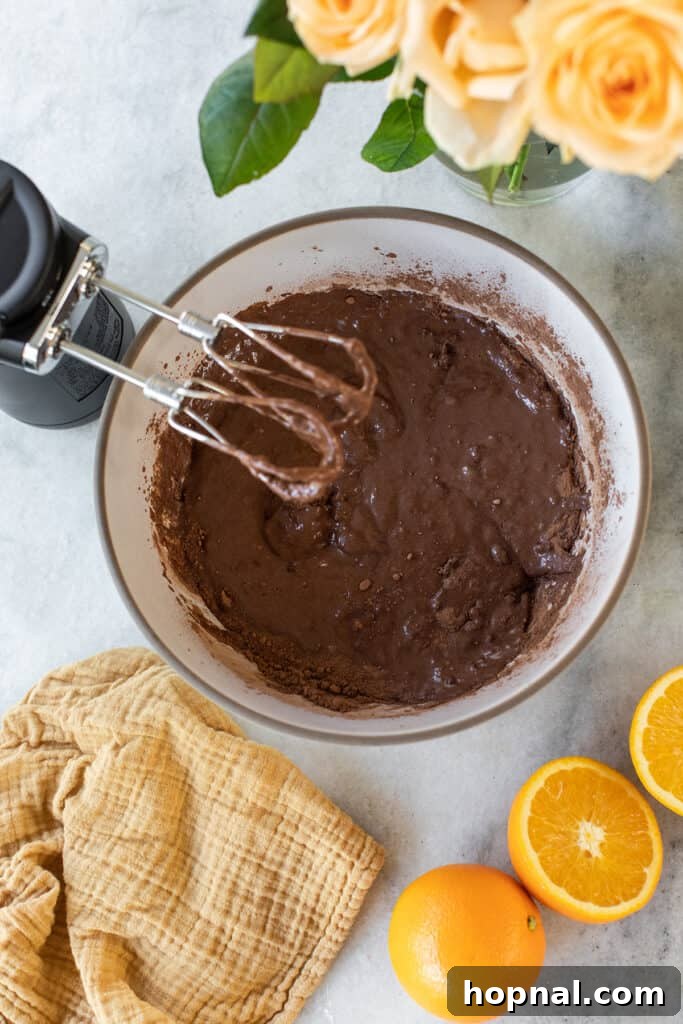 Close-up of chocolate cake batter being mixed, illustrating the rich color and texture.