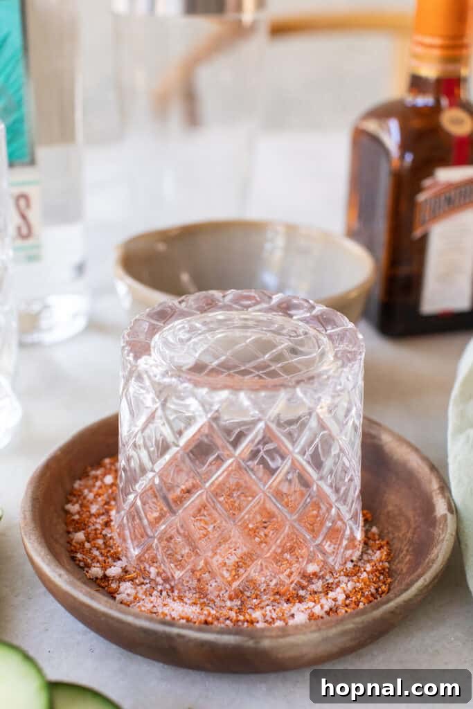 Expertly rimming a cocktail glass with a mixture of salt and Tajín for a flavorful edge.