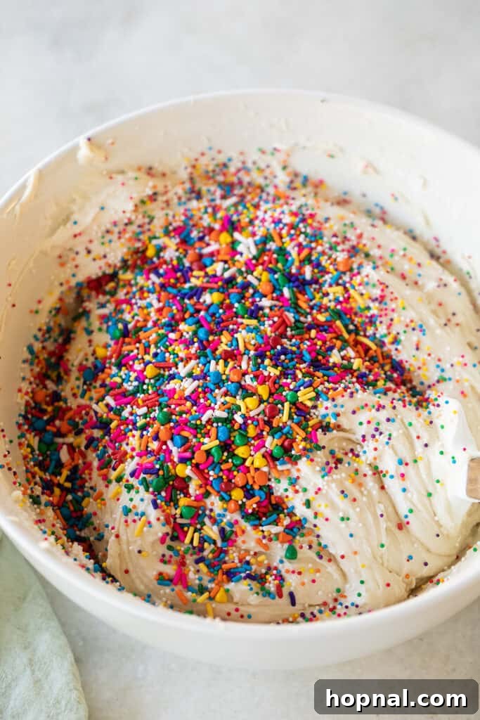 Folding in sprinkles to a vanilla cupcake batter.