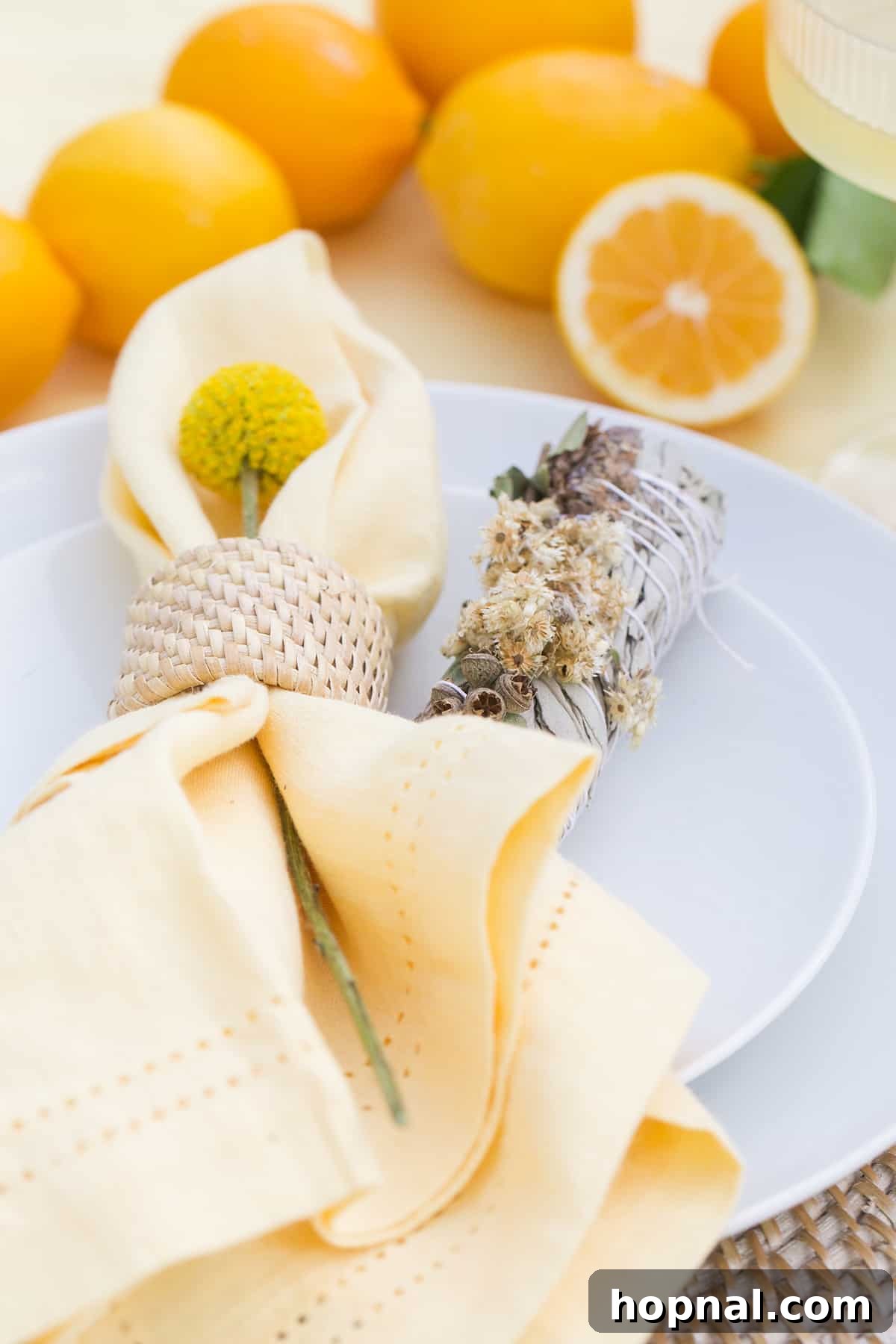 Spring Gatherings: A Lemon-Kissed Table 6 Close-up of a yellow linen napkin adorned with a fresh sage bundle, adding a natural and fragrant touch to the table setting.