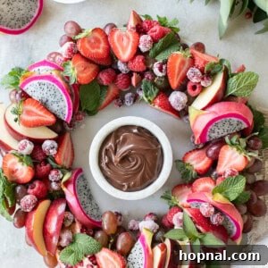 Christmas wreath platter with red fruit and chocolate dip.