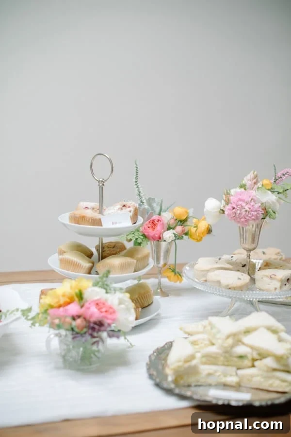 Mom's Garden Tea Oasis 5 Variety of delicious tea party food, including sandwiches and sweets, on a decorated table
