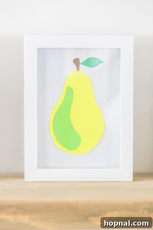 Paper strawberry art in a white frame