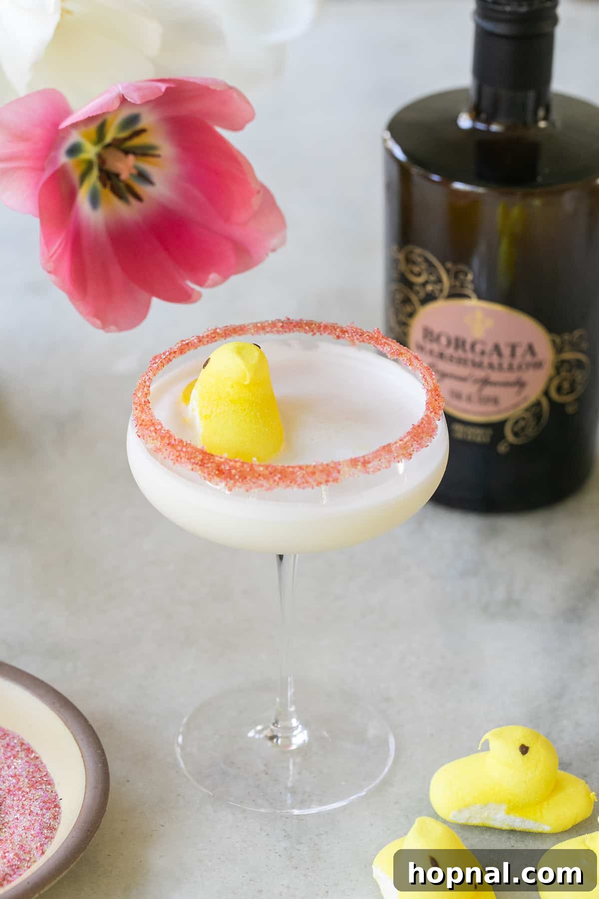 Peep cocktail with a sugared rim and a vibrant yellow Peep marshmallow floating on the top, ready for an Easter celebration.