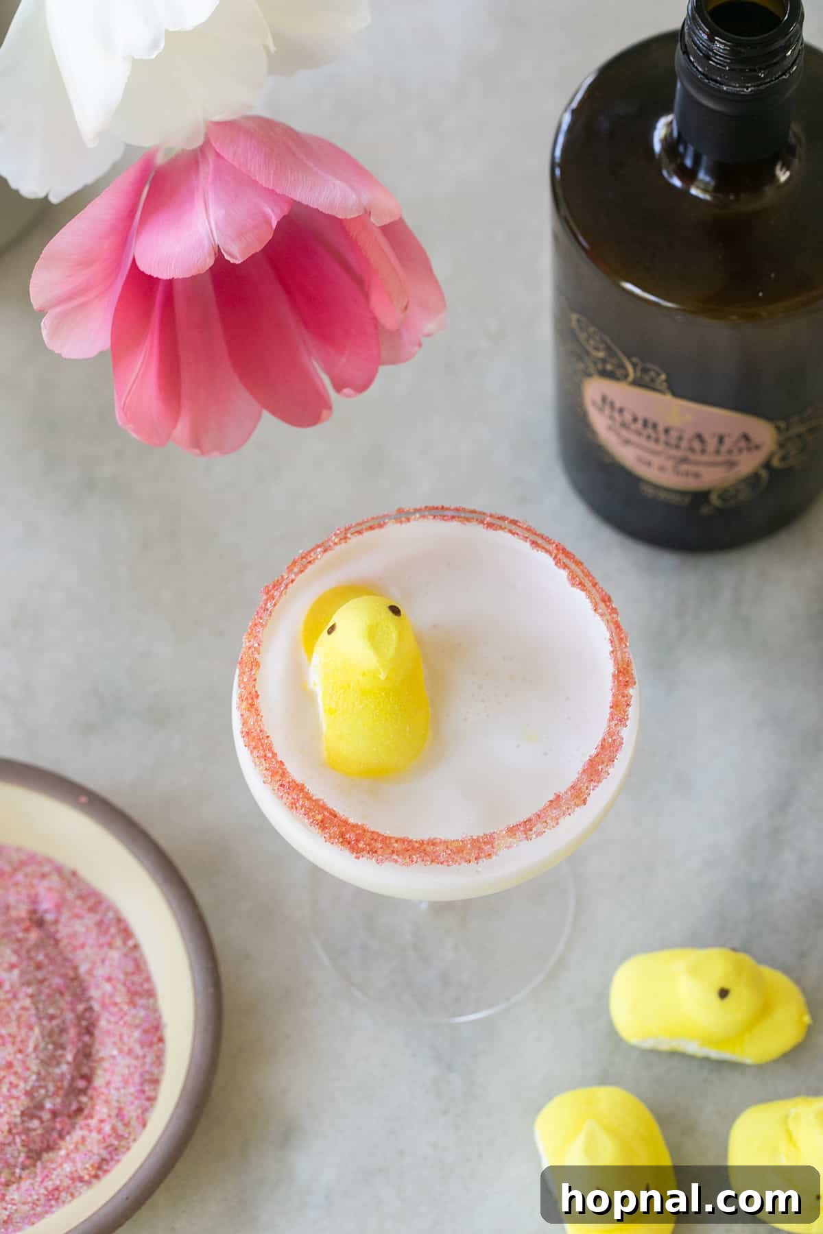 A sweet Peep marshmallow martini with a delicate pink sugar rim, garnished with a cheerful yellow Peep marshmallow on top, capturing the essence of Easter festivities.