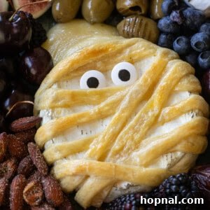 Mummy brie with eyes on a cheese platter.