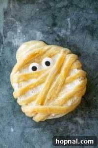 Baked mummy brie with gooey cheese and sprinkle eyes.