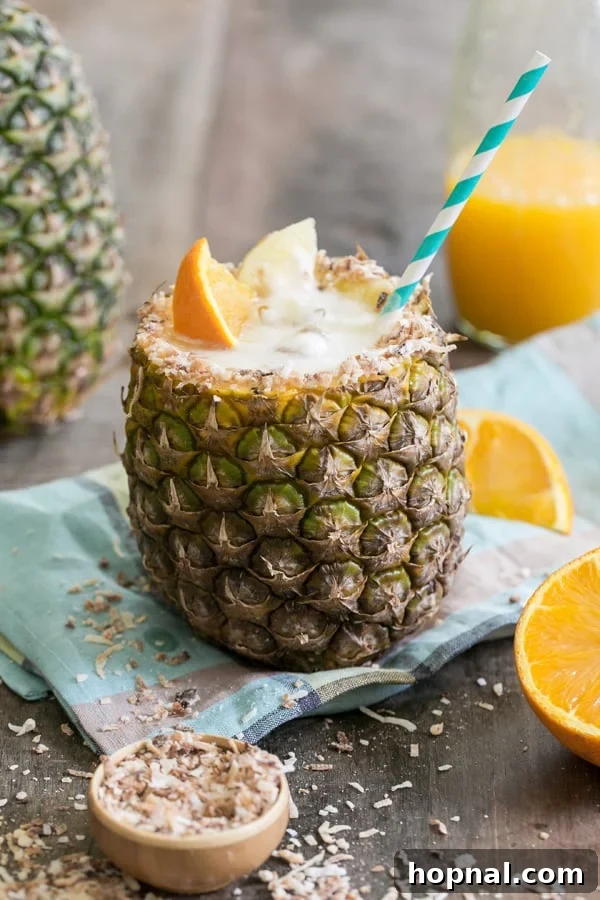 A refreshing pineapple cocktail generously filled inside a hollowed-out pineapple, ready to be enjoyed.