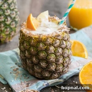 A deliciously refreshing Toasted Coconut Pineapple Rum Cocktail served in a beautifully carved pineapple cup.