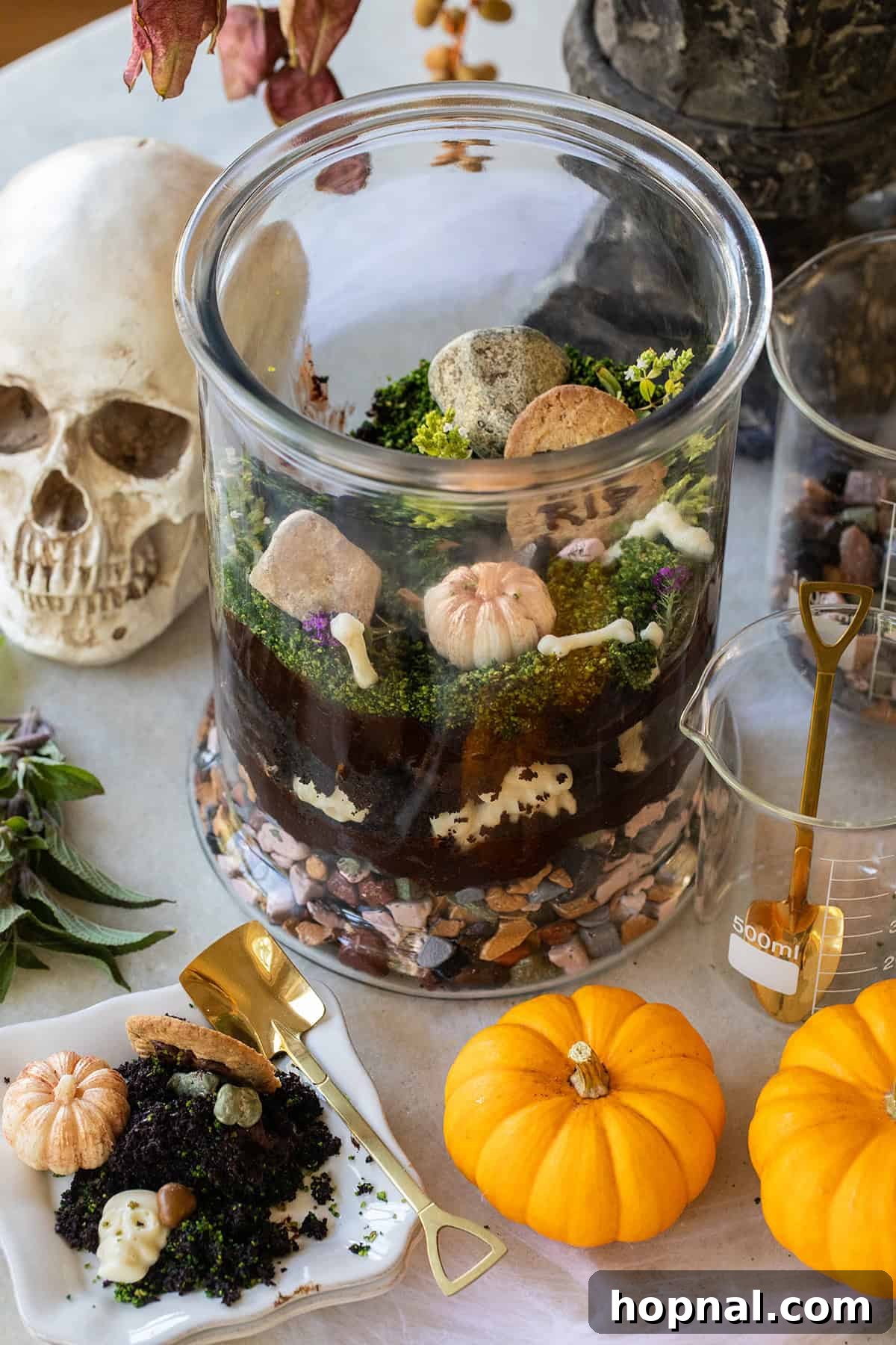 Edible Halloween Terrarium with crumbled chocolate cake, rich frosting, crunchy edible rocks, and spooky white chocolate bones, creating a haunted graveyard scene.