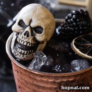 Halloween Moscow mule with blackberries, ginger and black vodka served in a copper cup.