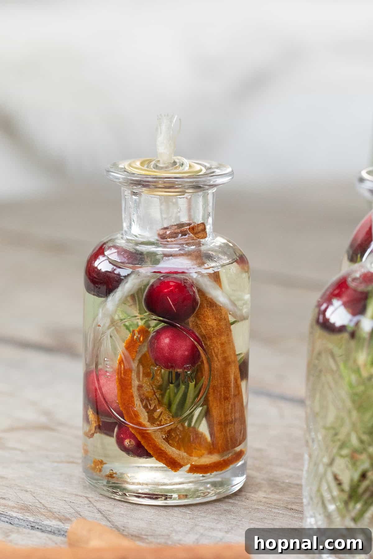 A visual guide demonstrating how to make a natural, non-toxic oil candle using a glass jar, oil, and a simple cotton wick.