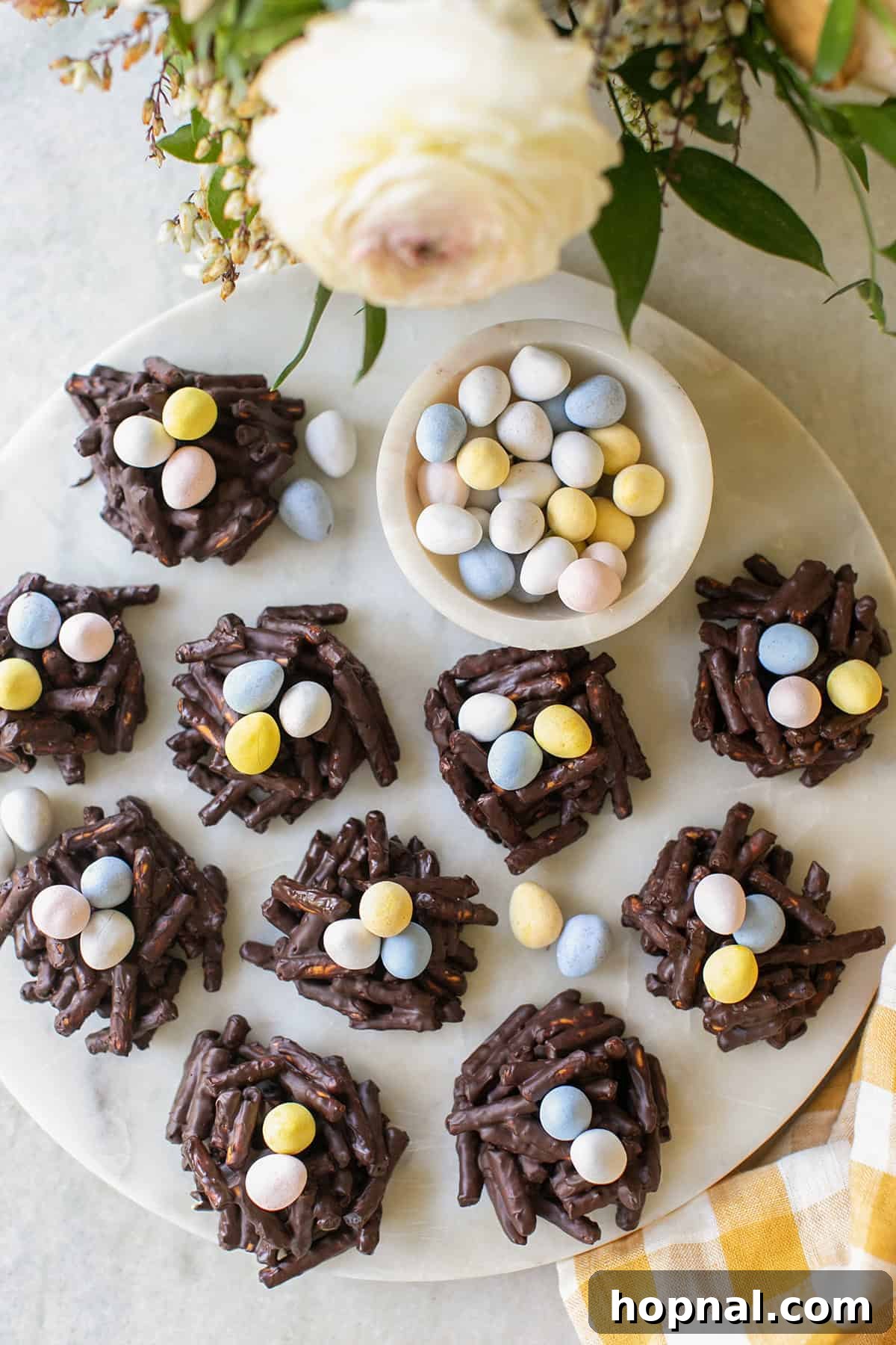 Sweet Spring Nests 3 A beautifully arranged platter showcasing numerous Bird's Nest Cookies, each with a small indentation and candy eggs, ready for serving at a spring event.