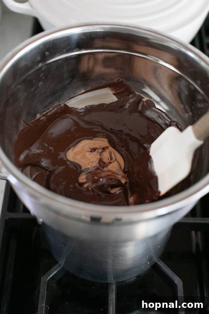Sweet Spring Nests 6 Creamy peanut butter being stirred into the melted chocolate, creating a smooth, combined mixture.