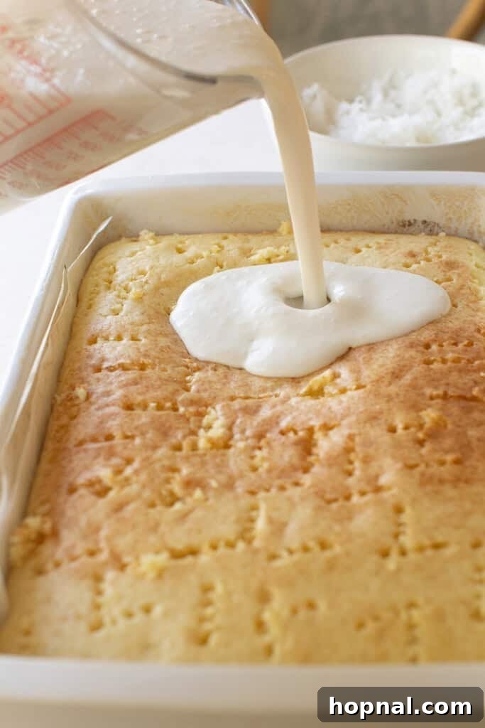 Pouring coconut cream over a baked cake.