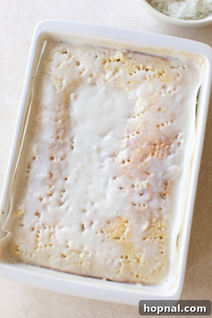 Coconut cream seeping into a poke cake.