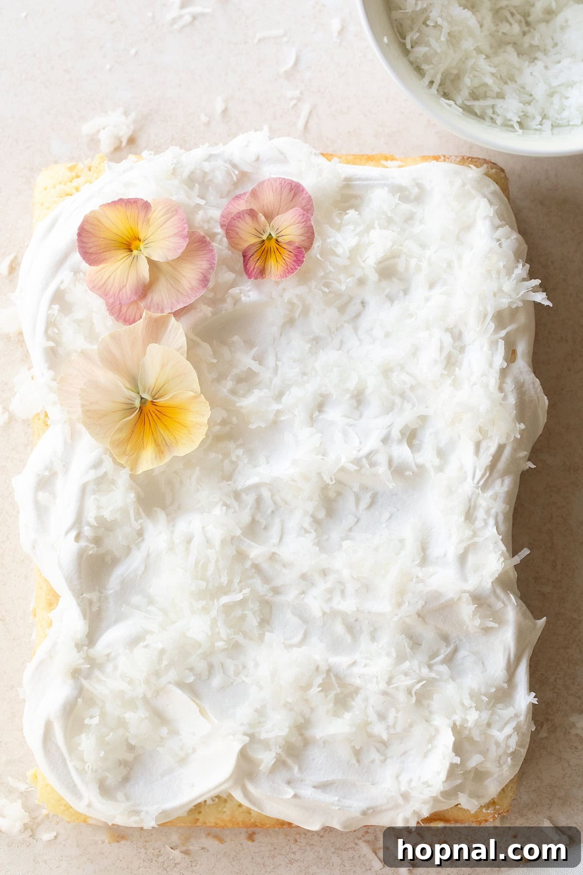 Coconut poke cake with shredded coconut.
