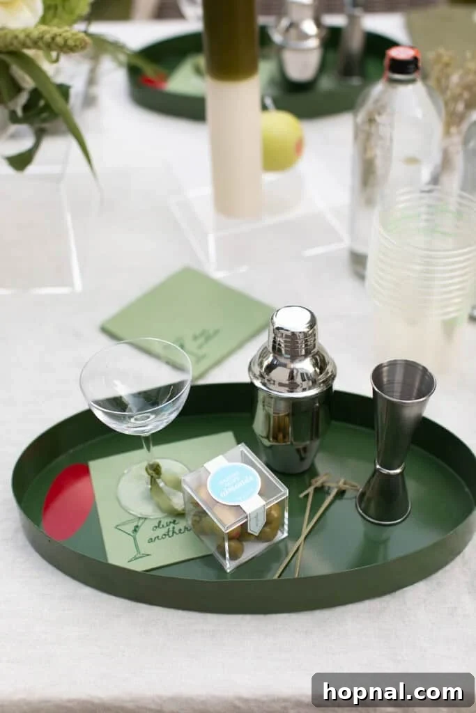 A neatly arranged dirty martini station, featuring a gleaming cocktail shaker, a precise jigger, and crisp napkins, ready for cocktail crafting.