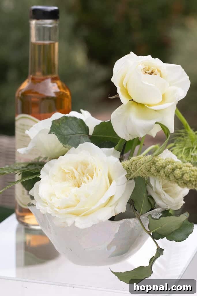 Elegant floral arrangements for a dirty martini party, incorporating olive branches and soft green hues to complement the theme.