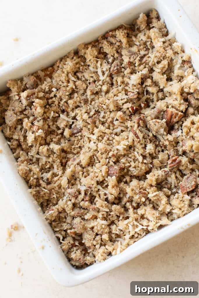Warm Spiced Pumpkin Crumb Cake 7 The golden-brown coconut-pecan crumb topping beautifully sprinkled over the unbaked homemade pumpkin coffee cake batter in a baking pan.