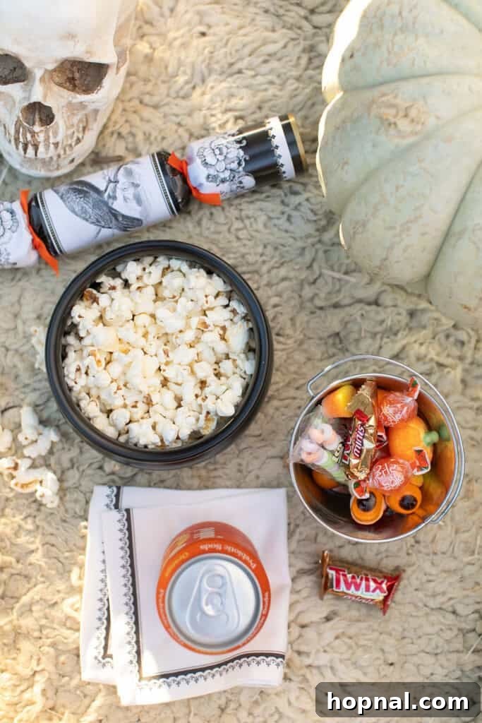 Outdoor Halloween movie snacks with candy and popcorn.