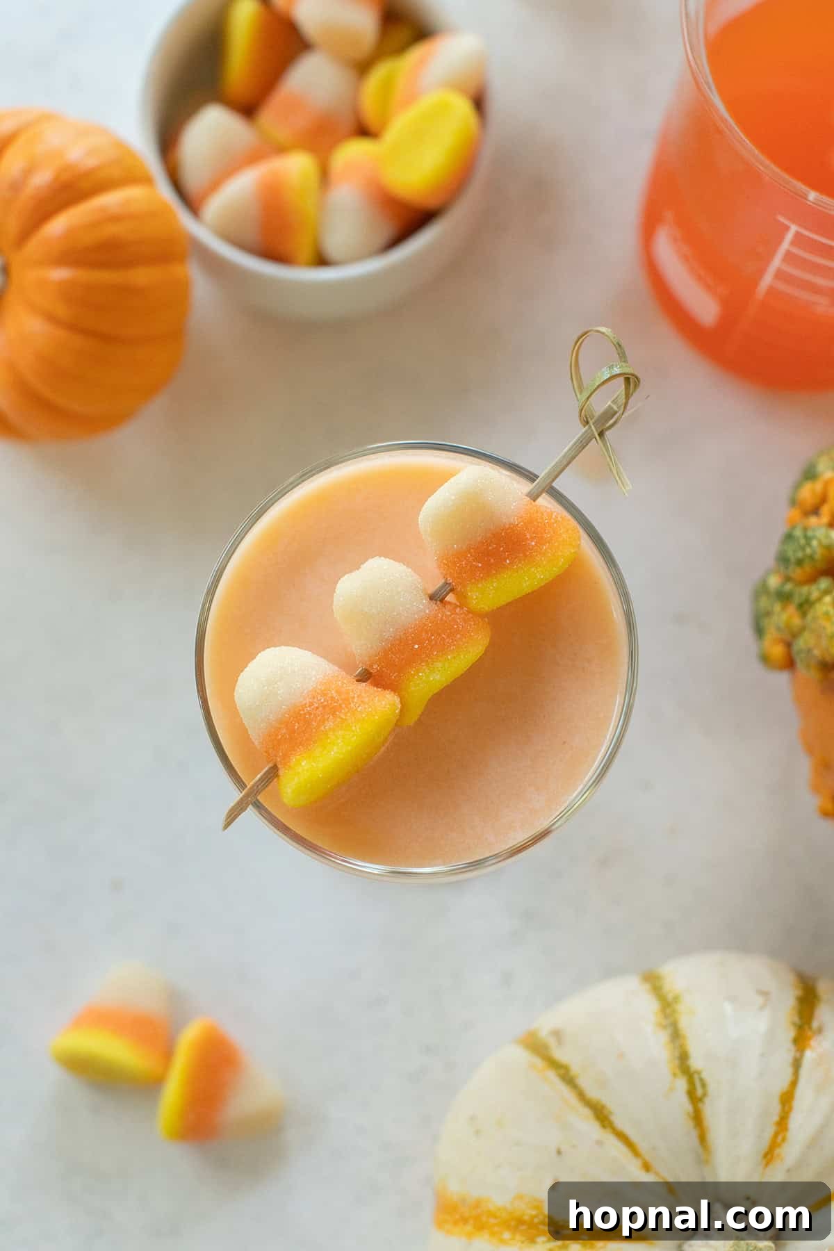 Sweet Halloween cocktail crafted with candy corn infused vodka and rich cream, presented in a coupe glass.