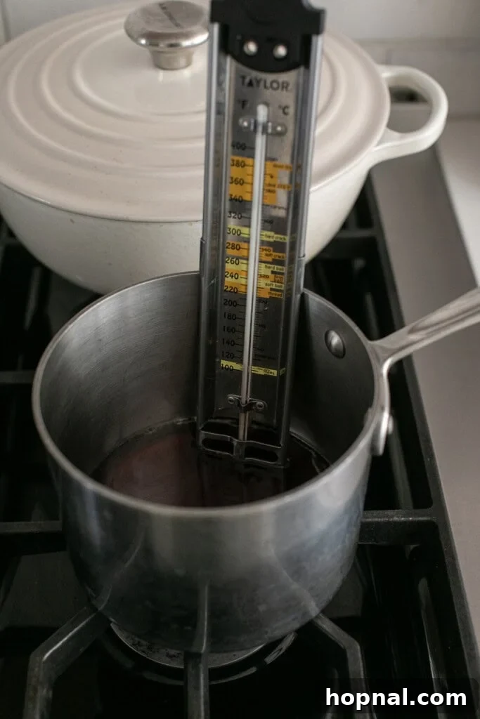 Pillowy Maple Dreams 4 Boiling maple syrup to make marshmallows in a saucepan with a candy thermometer.