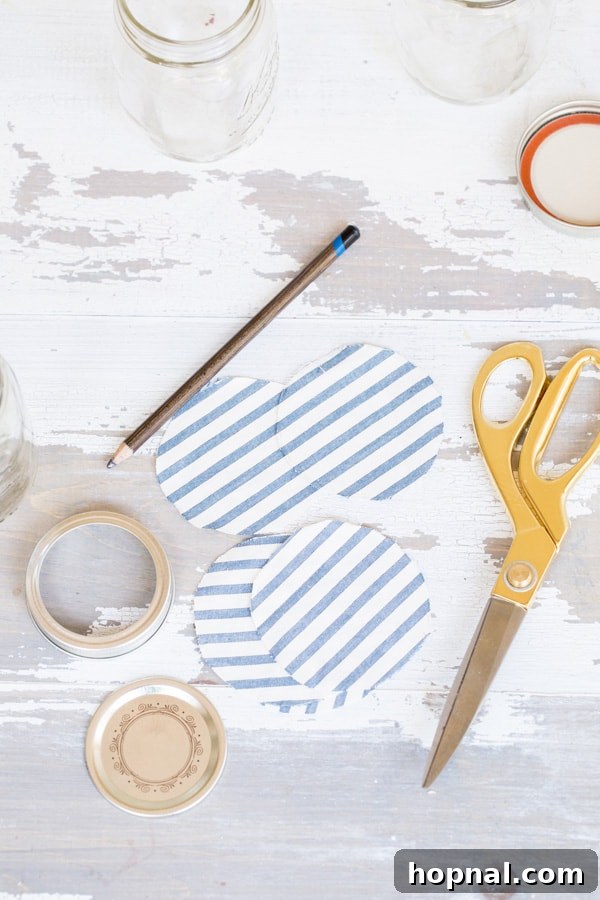 Party Perfect Festive Jar Decor 5 Craft supplies neatly laid out for preparing DIY fabric lid canning jars, including patterned fabric, scissors, a pen, and a canning jar lid.