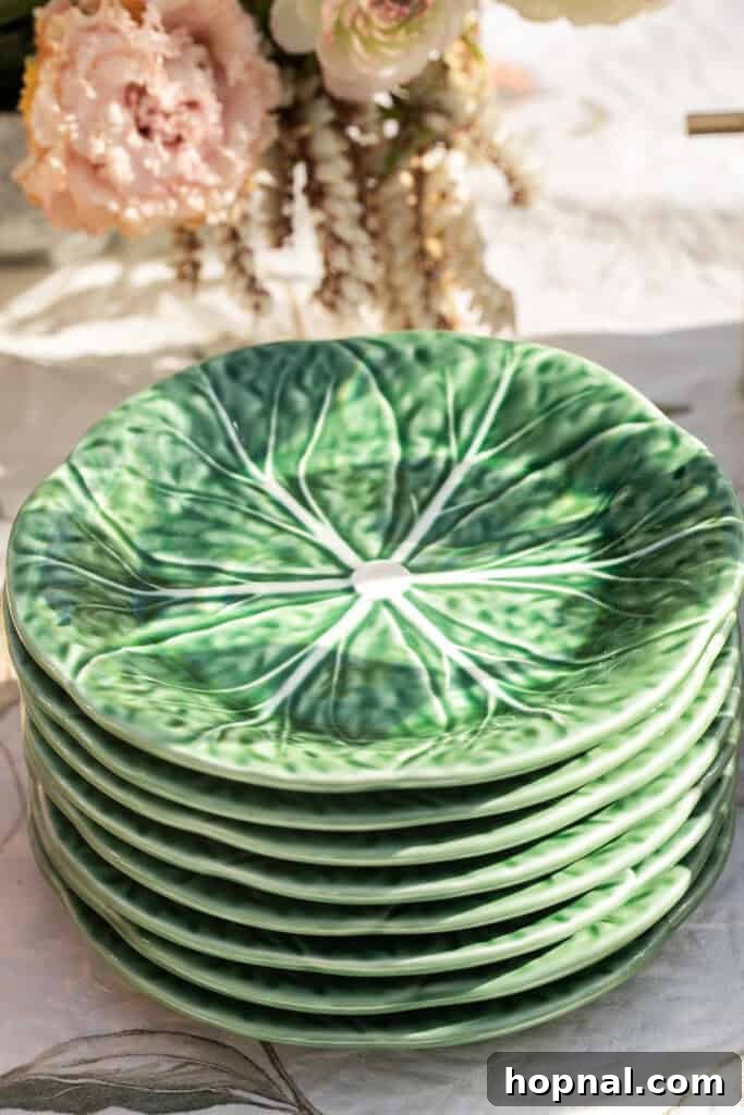 Charming cabbage-leaf plates stacked neatly, adding a whimsical and natural touch to the garden party table setting.
