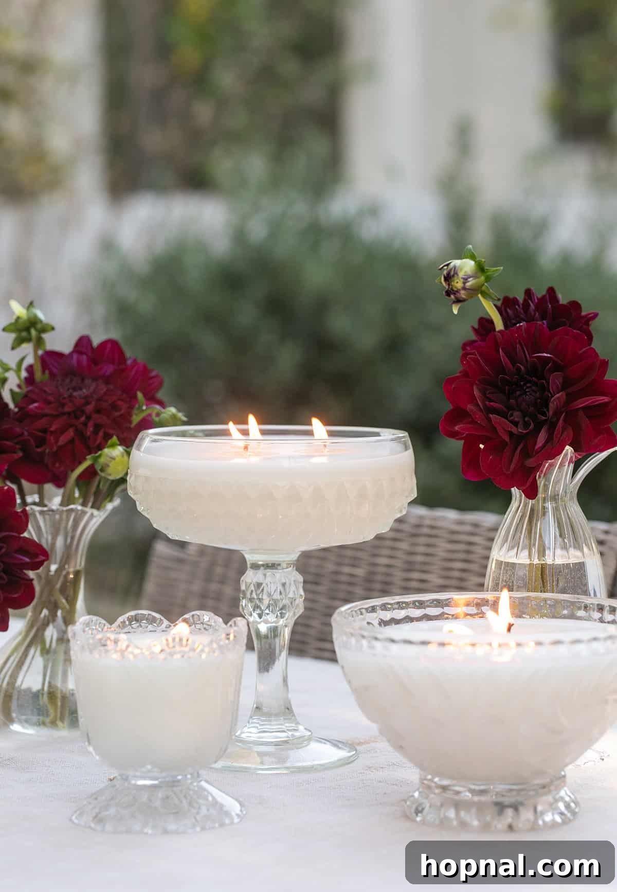 Homemade candles in vintage glassware glowing at night.