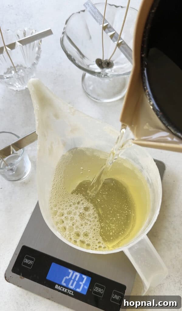 Pouring hot apricot coconut wax into a plastic pouring container to make candles. 