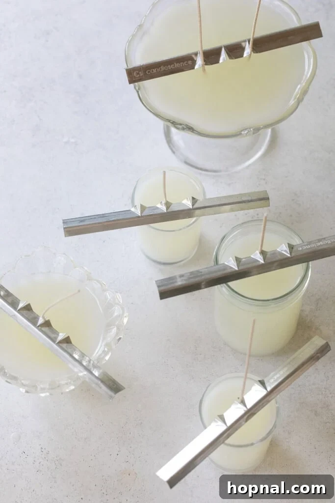 Homemade candles curing with wick holders.
